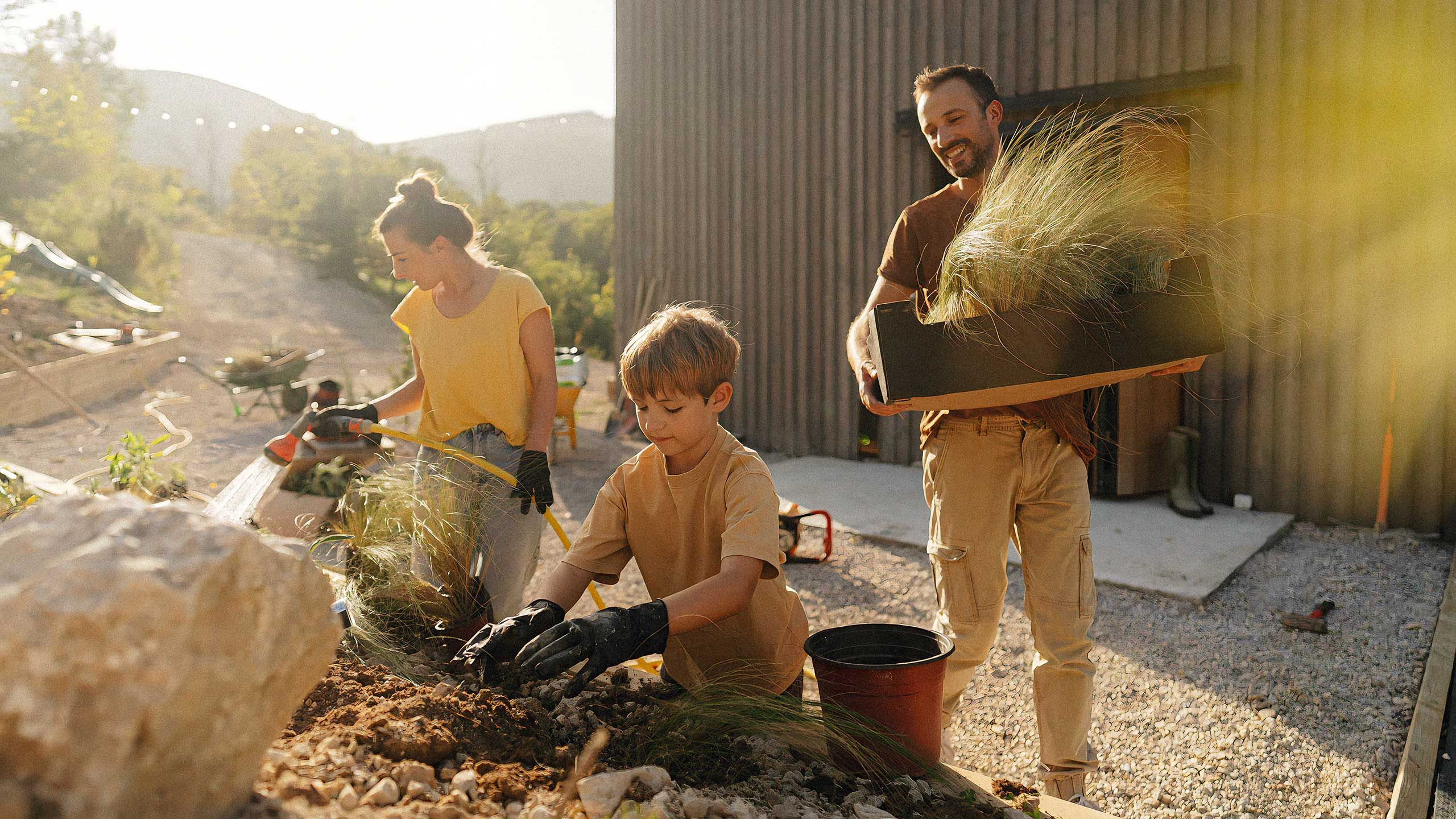 Family planting grasses together in a new home garden