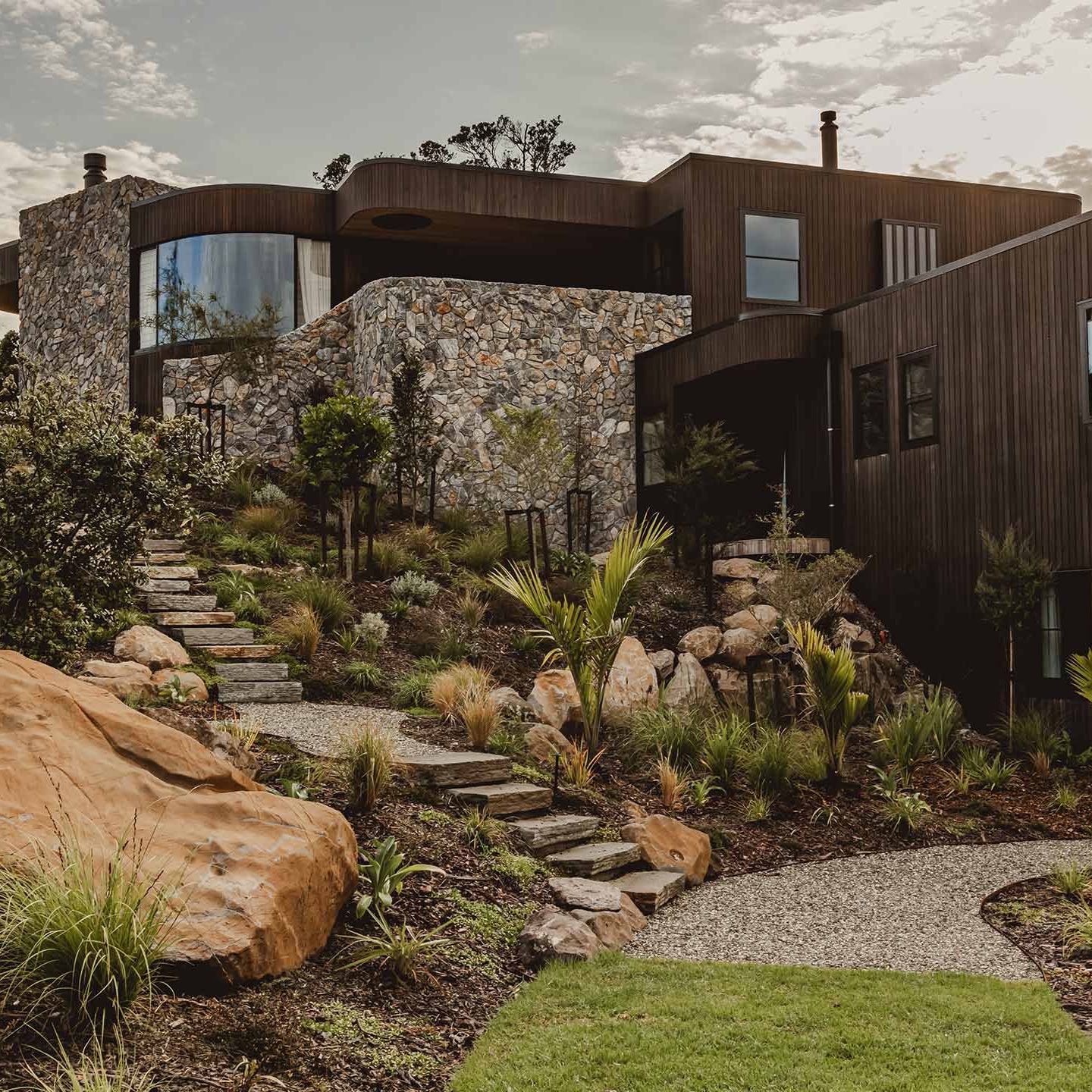 Modern home with landscaped gravel paths, boulders and native planting
